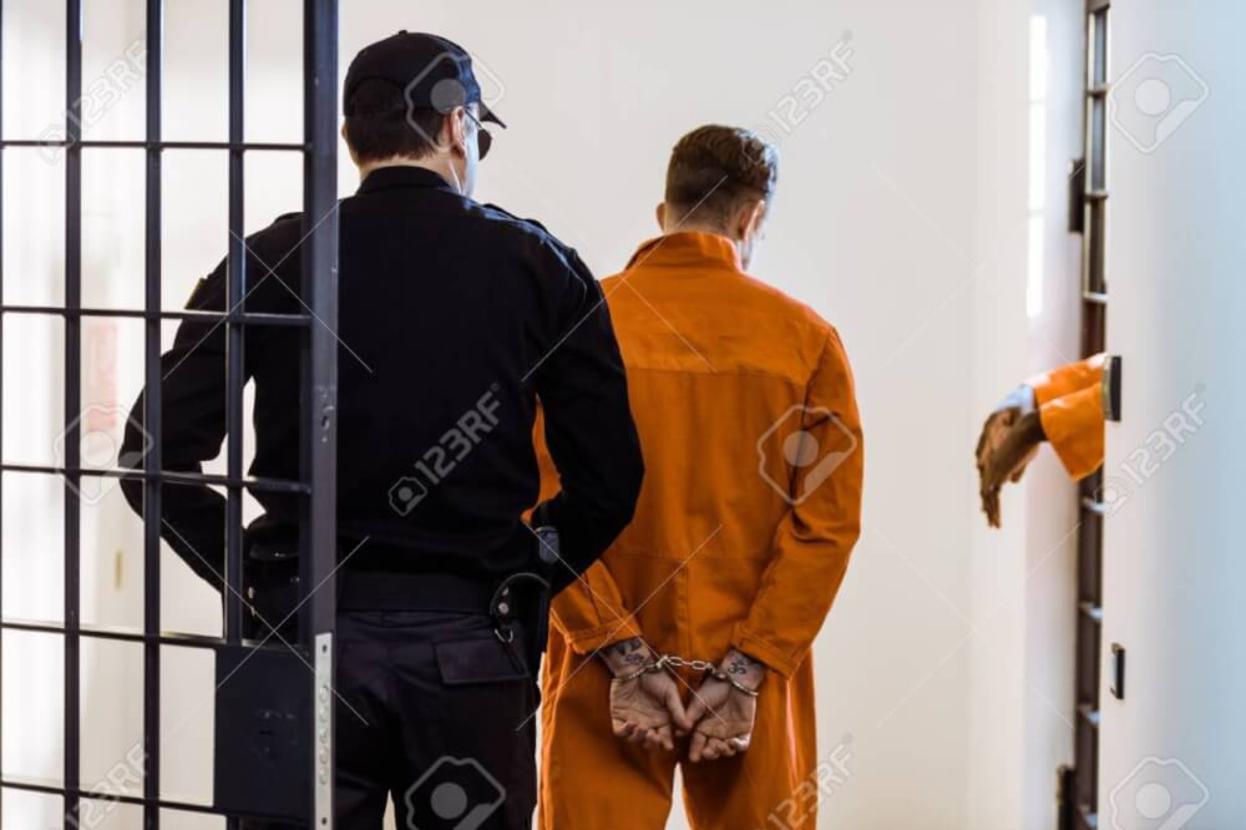 back view of security guard leading criminal in handcuffs